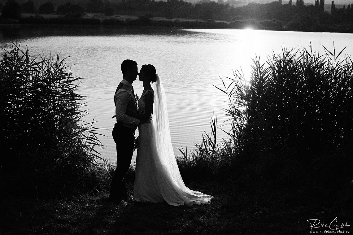 černobílá svatební fotografie novomanželů u rybníku