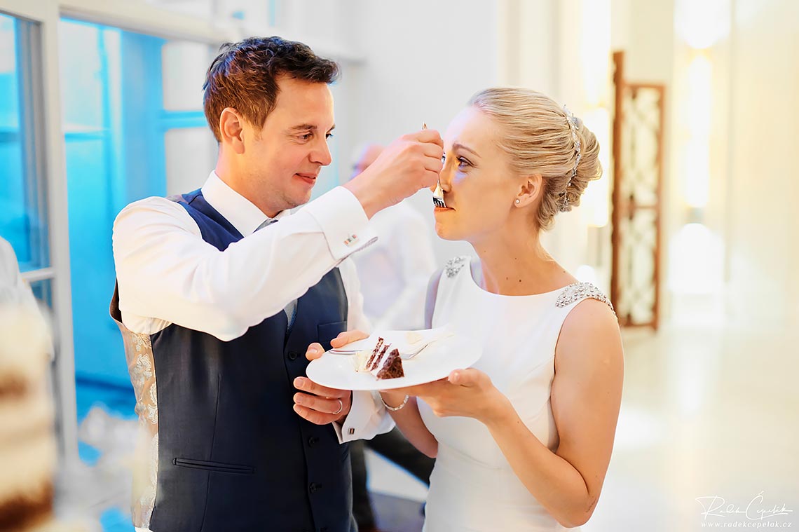 nevěsta a ženich ochutnávají svatební dort