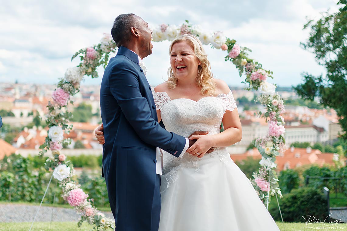 ženich a nevěsta s úsměvem po svatebním obřadu v Praze