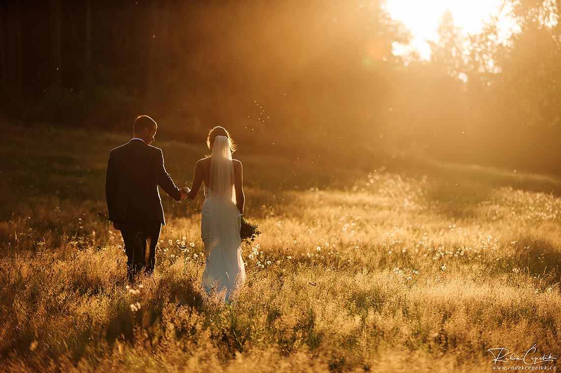 Svatební fotografie ženicha a nevěsty při západu slunce v přírodě