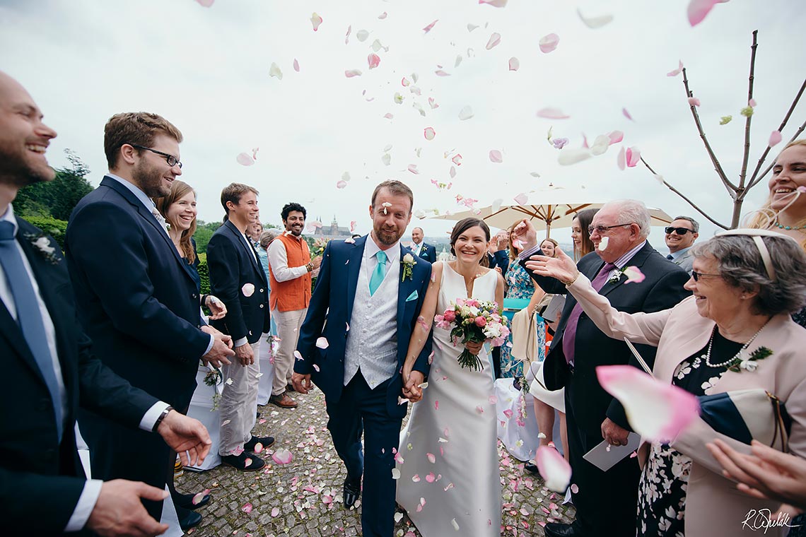 nevěsta a ženich odchází pranýřem po svatebním obřadu na Nebozízku v Praze