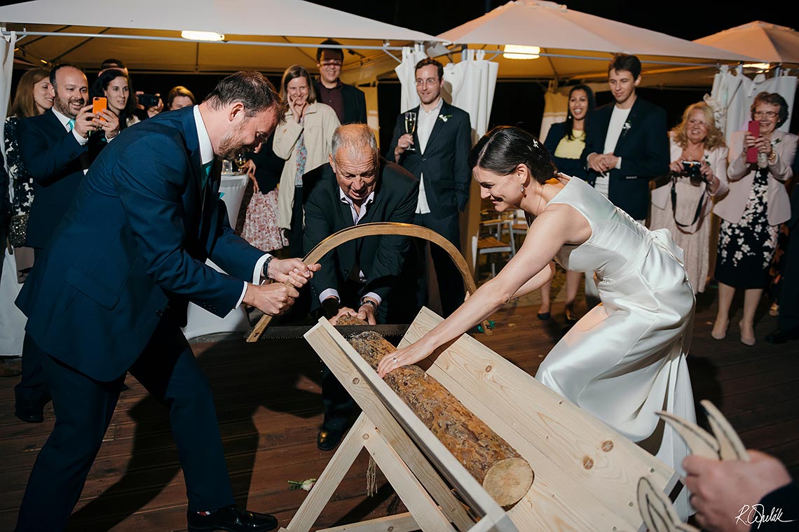 nevěsta a ženich při řezání dřevěného špalku
