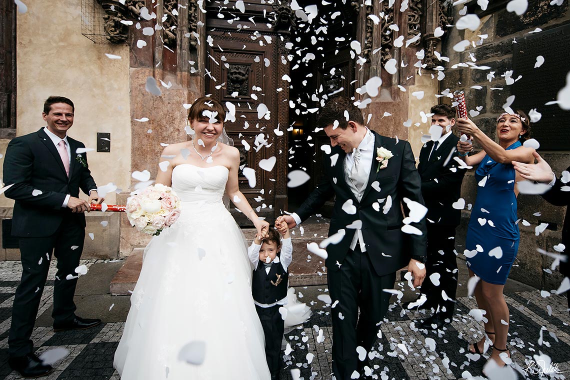 nevěsta s ženichem procházející pranýřem se srdíčkovými konfetami