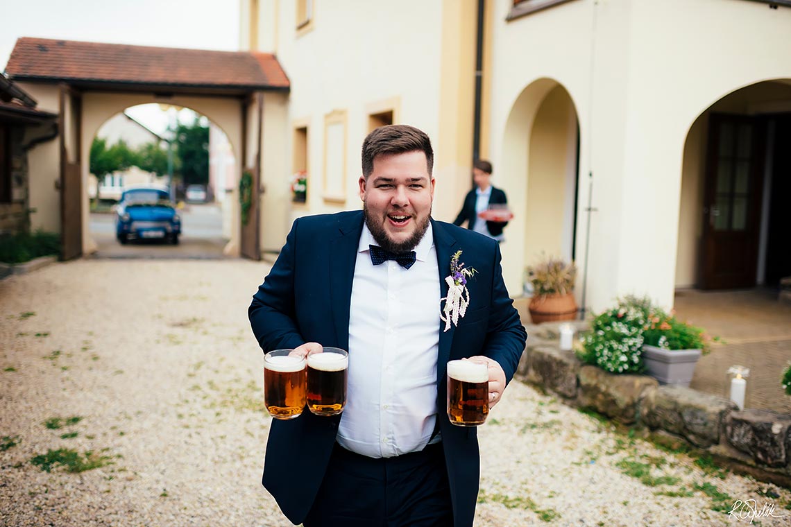 ženich nesoucí piva na svatbě