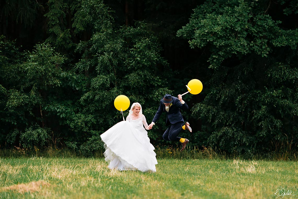 veselá svatební fotografie novomanželů na louce u lesa