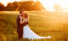 svatební foto ženicha a nevěsty v poli při západu slunce