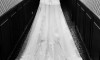 černobílá svatební fotografie nevěsty ve svatebních šatech s vlečkou