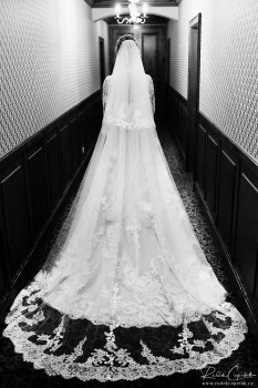 černobílá svatební fotografie nevěsty ve svatebních šatech s vlečkou