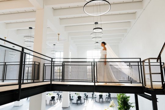 svatební fotografie nevěsty, která jde v prostoru hostiny s dlouhým závojem