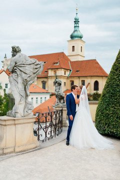 ženich a nevěsta na focení v Praze ve Vrtbovské zahradě s kostelem na pozadí