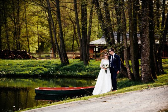 fotografie nevěsty a ženicha u rybníku v areálu Hodějovického mlýna s loďkou u břehu