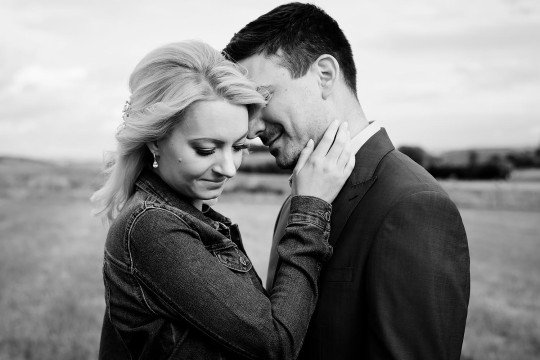 černobílá fotografie nevěsty v džínové bundě se ženichem